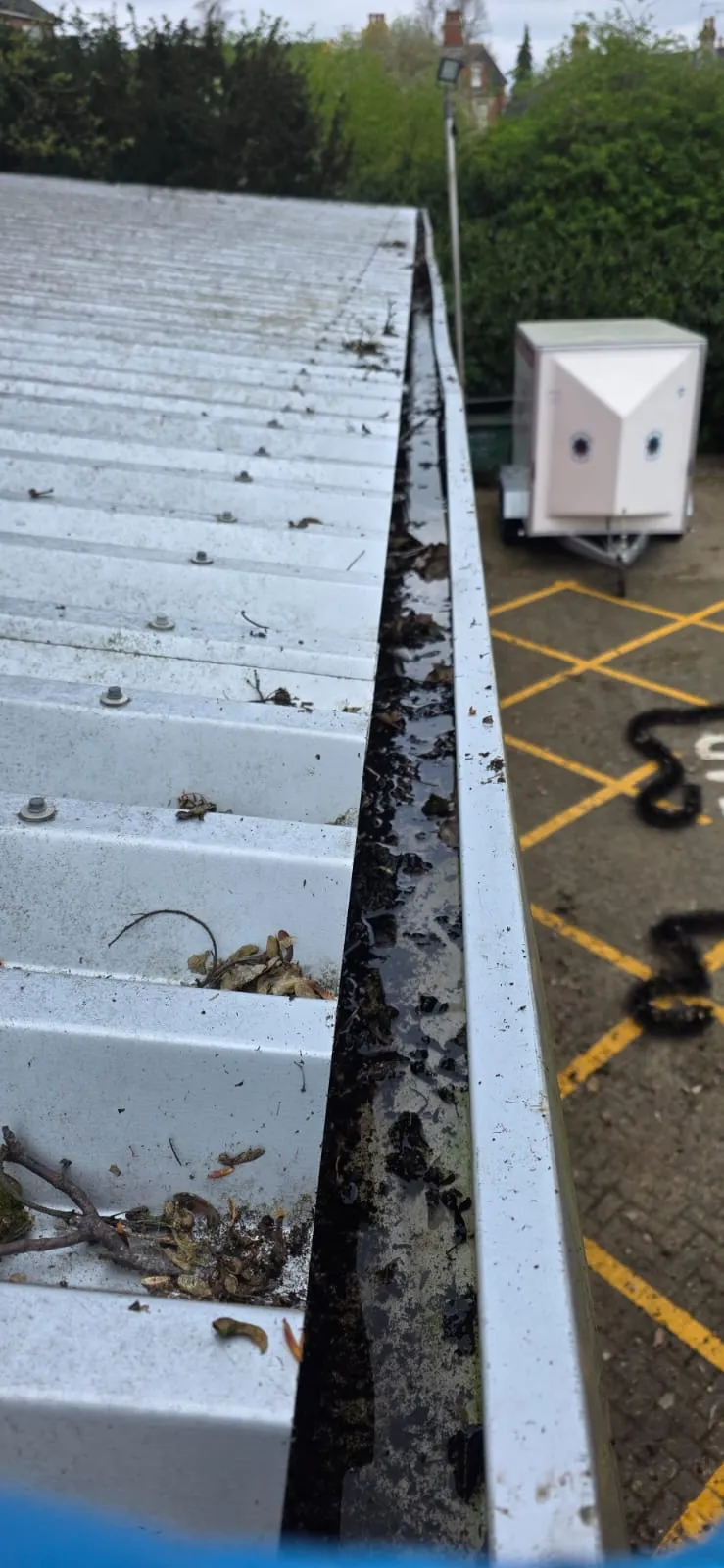Blocked commercial guttering needing cleaning and moss removal in Felixstowe.