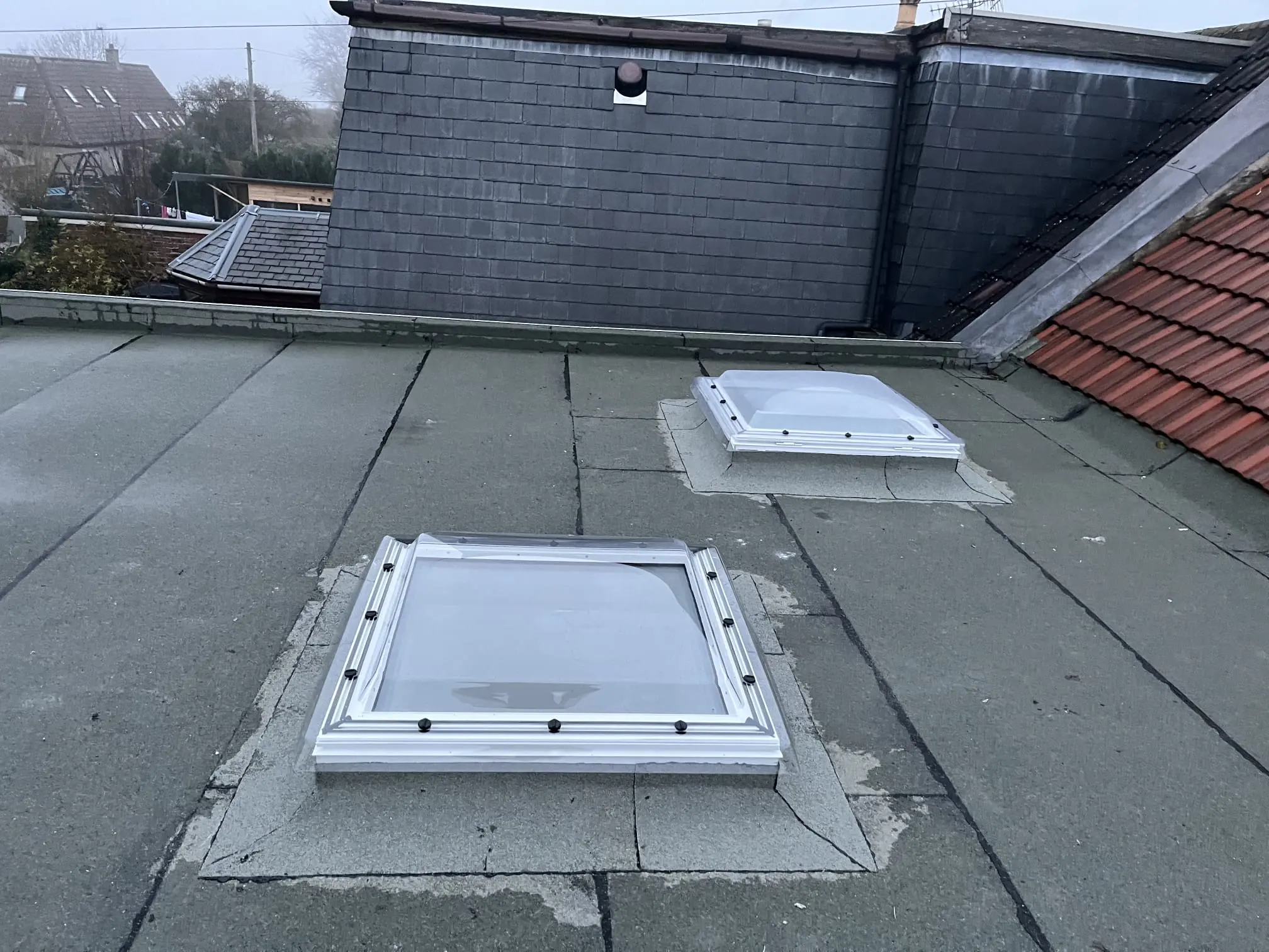 A picture of a flat roof with newly installed skylights by RM & SON ROOFING & PROPERTY CARE
