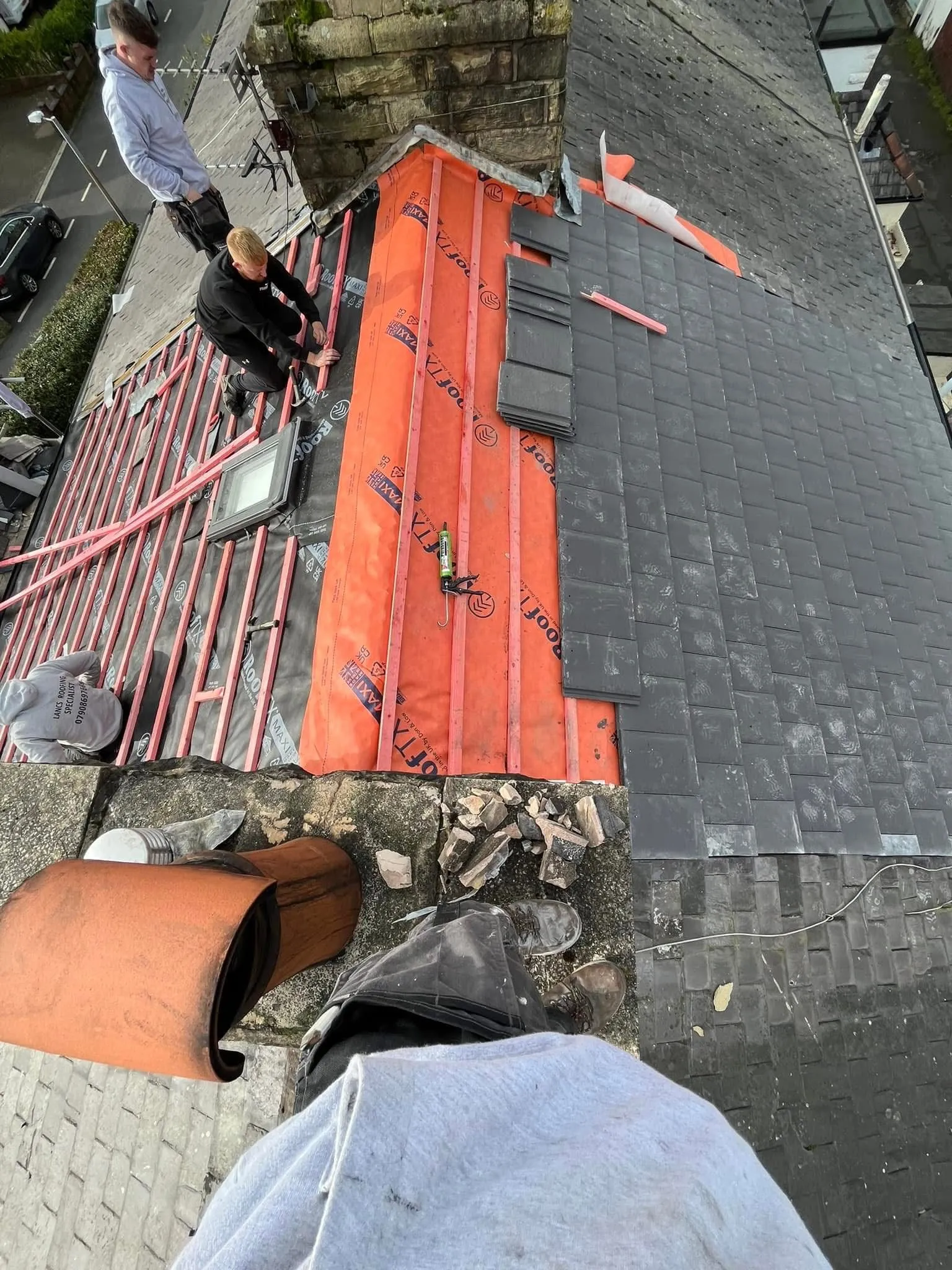Expert roofers installing slate tiles on a new pitched roof in Blackburn, Lancashire.