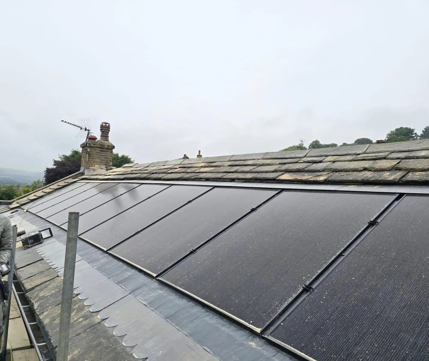 Integrated solar panels on a traditional Yorkshire stone slate pitched roof.