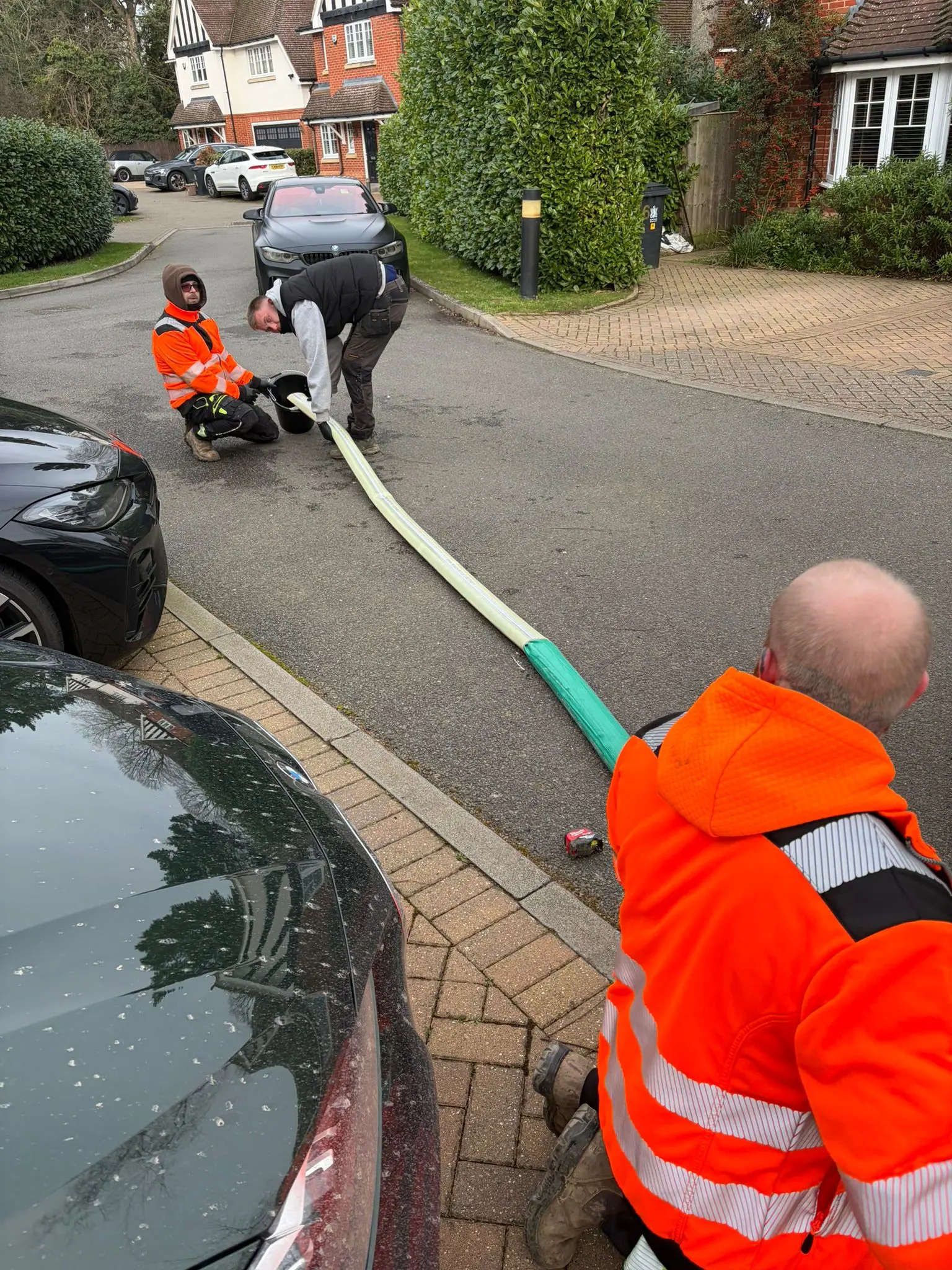 Buckinghamshire & Berkshire Drainage team preparing a no-dig drain liner on a residential road.