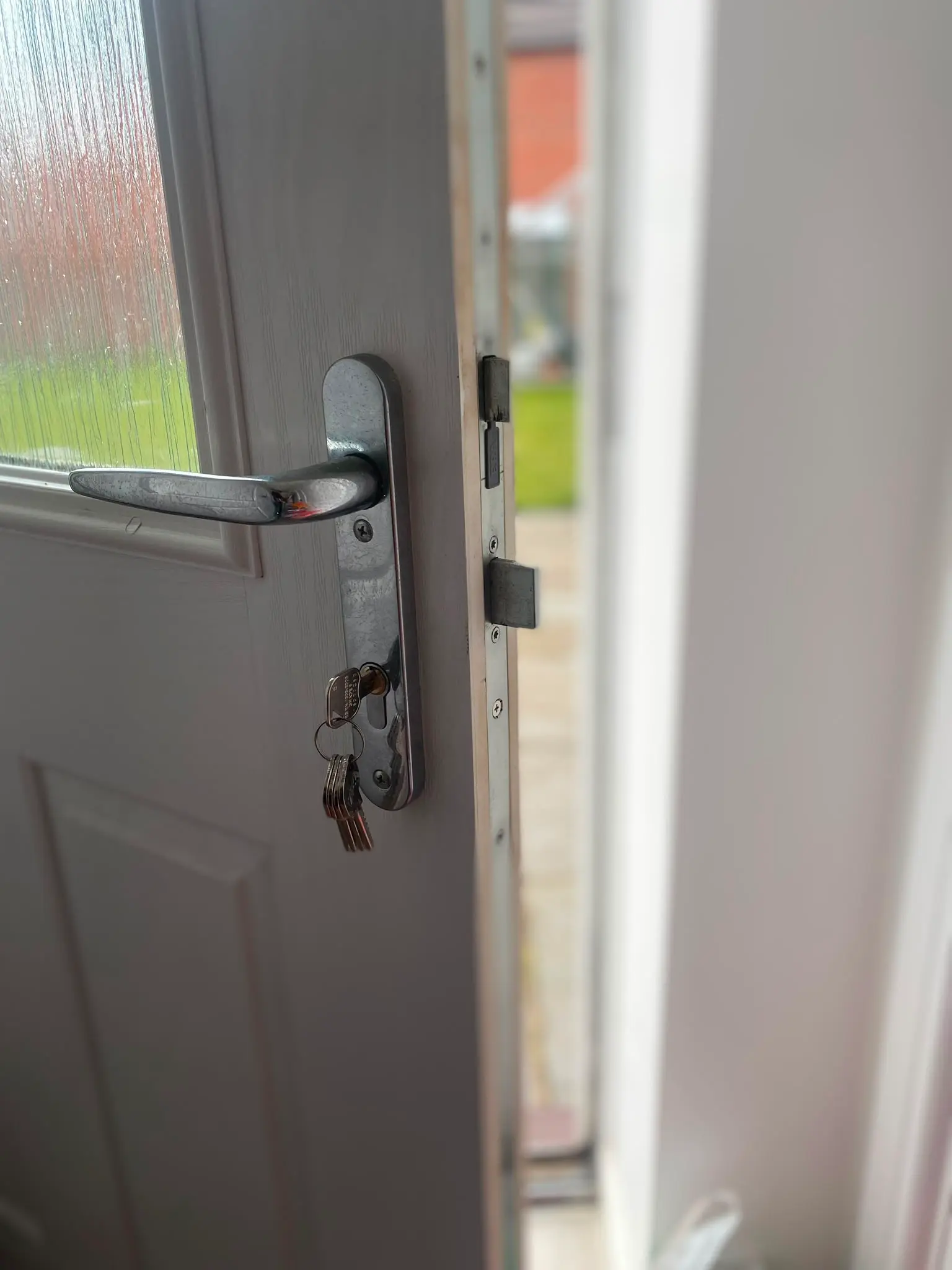 Close-up of a uPVC door handle, euro cylinder lock with keys, and multi-point locking strip