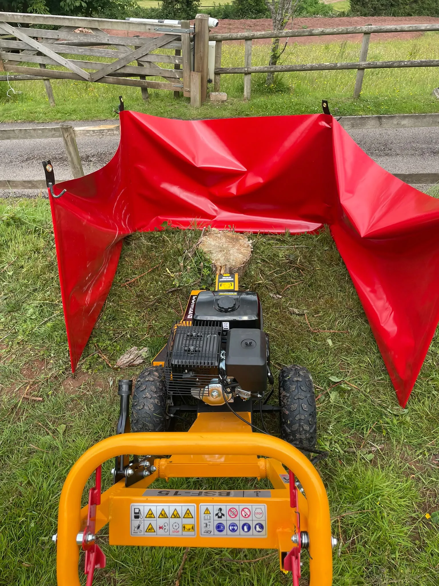 Tree stump grinding equipment prepared for operation with red protective debris screens