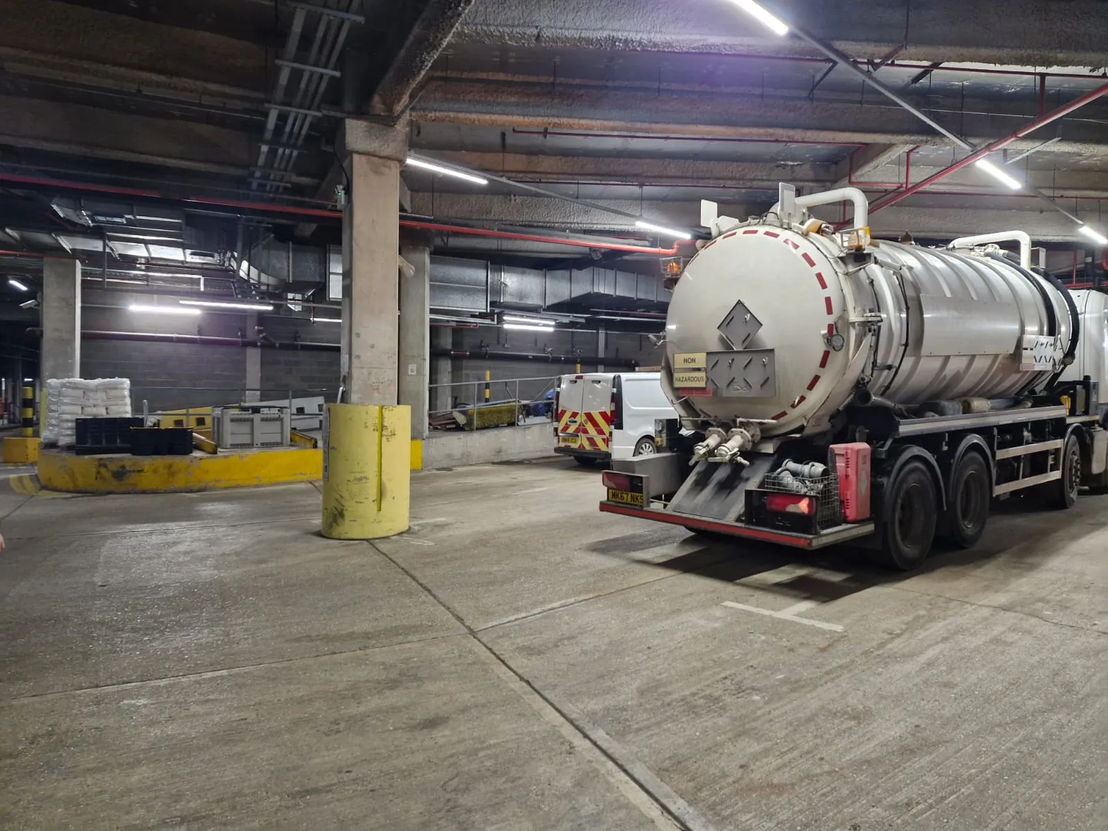 A professional vacuum tanker truck in a commercial parking area for liquid waste management services.