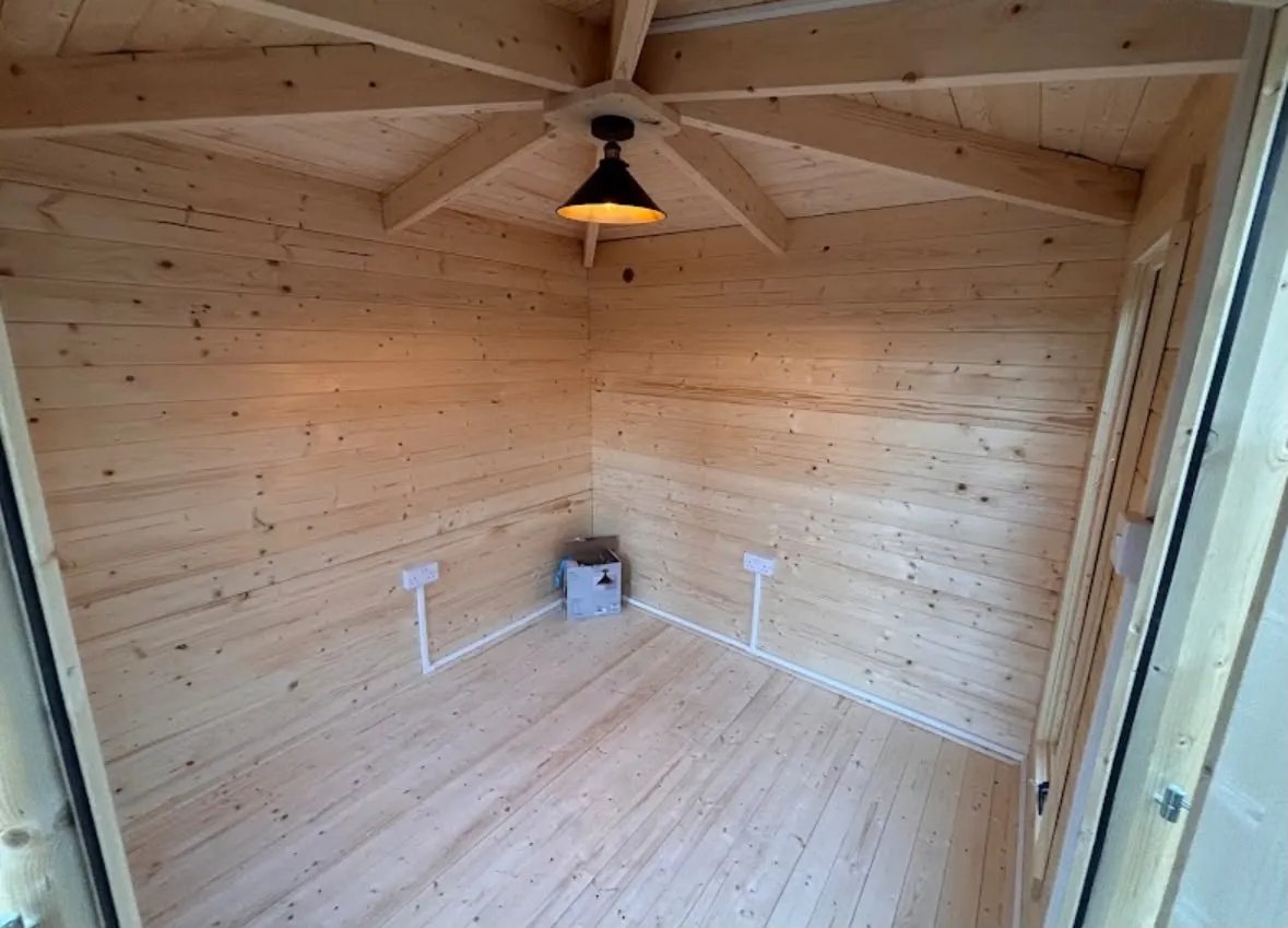 Garden office electrical installation with sockets and ceiling pendant light in a timber outbuilding