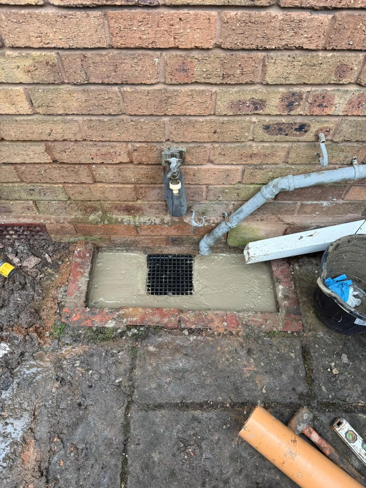 A newly installed gully drain with fresh concrete and waste pipe connection at a property in Bournemouth.