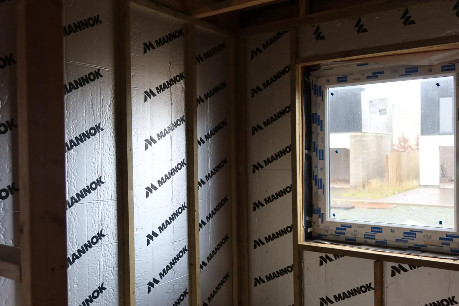 Rigid foil-faced internal wall insulation boards installed between timber studs in a residential room.