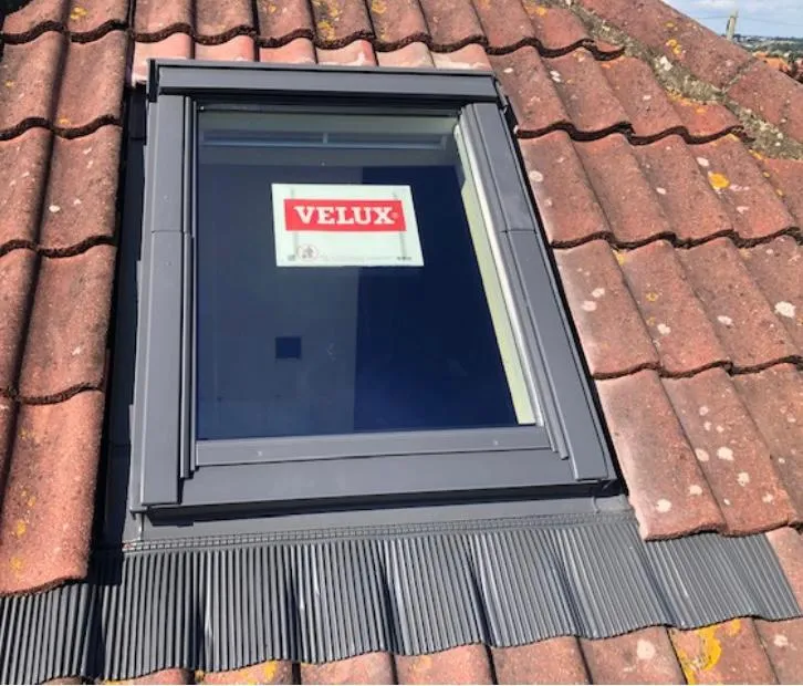 A newly fitted Velux roof window in a red tiled roof, demonstrating professional installation of roof lights.