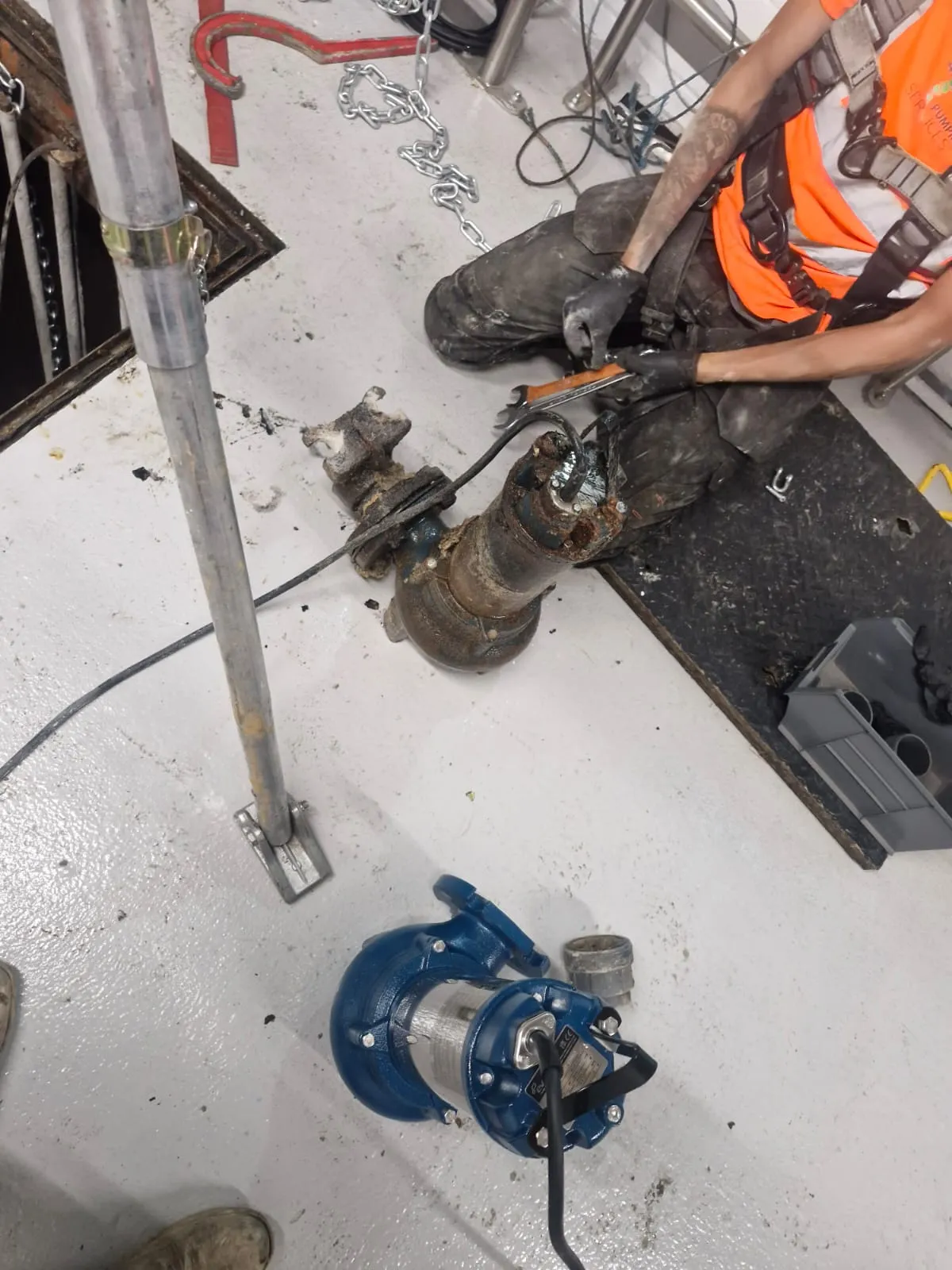 An engineer at Roberts Drainage Ltd replacing a wastewater pump during a pump station maintenance service.