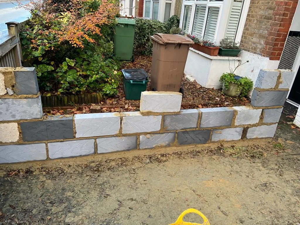 A new decorative garden wall being built as part of a landscaping project in a front garden.