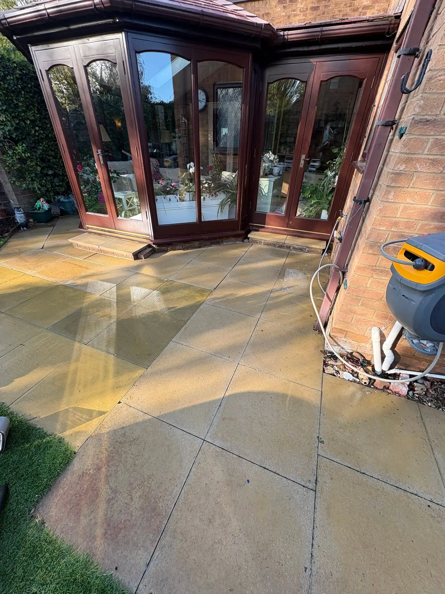 Newly installed sandstone patio around a conservatory