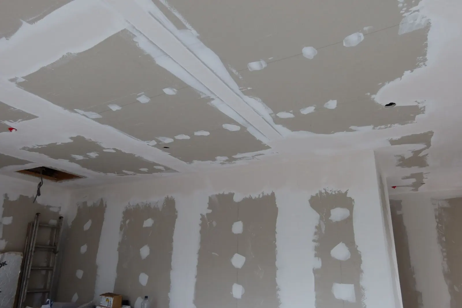 Newly installed plasterboard on walls and ceiling with taped and jointed seams during an internal wall insulation or renovation project