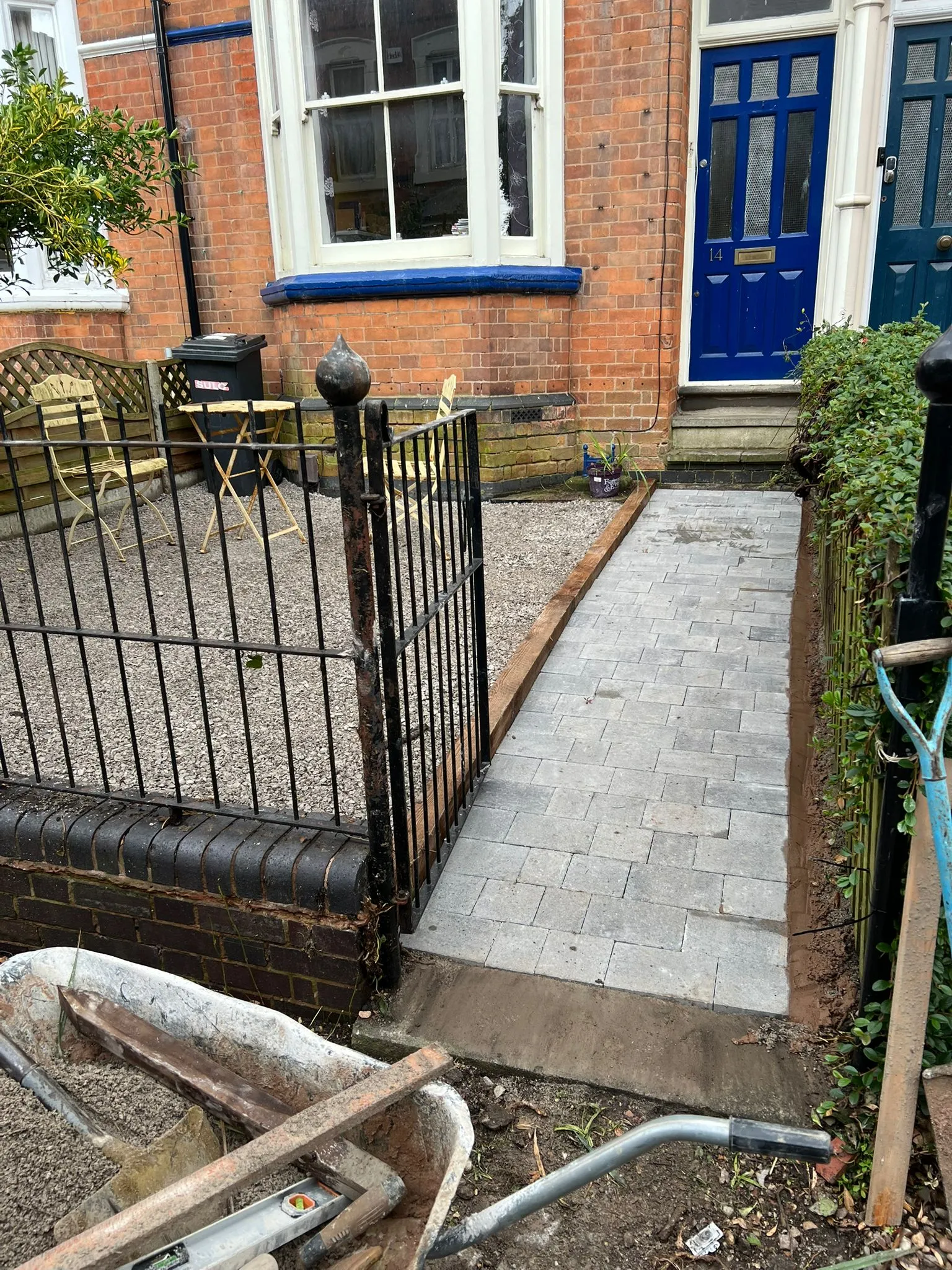Front garden landscaping project with newly installed grey block paving path and gravel area.
