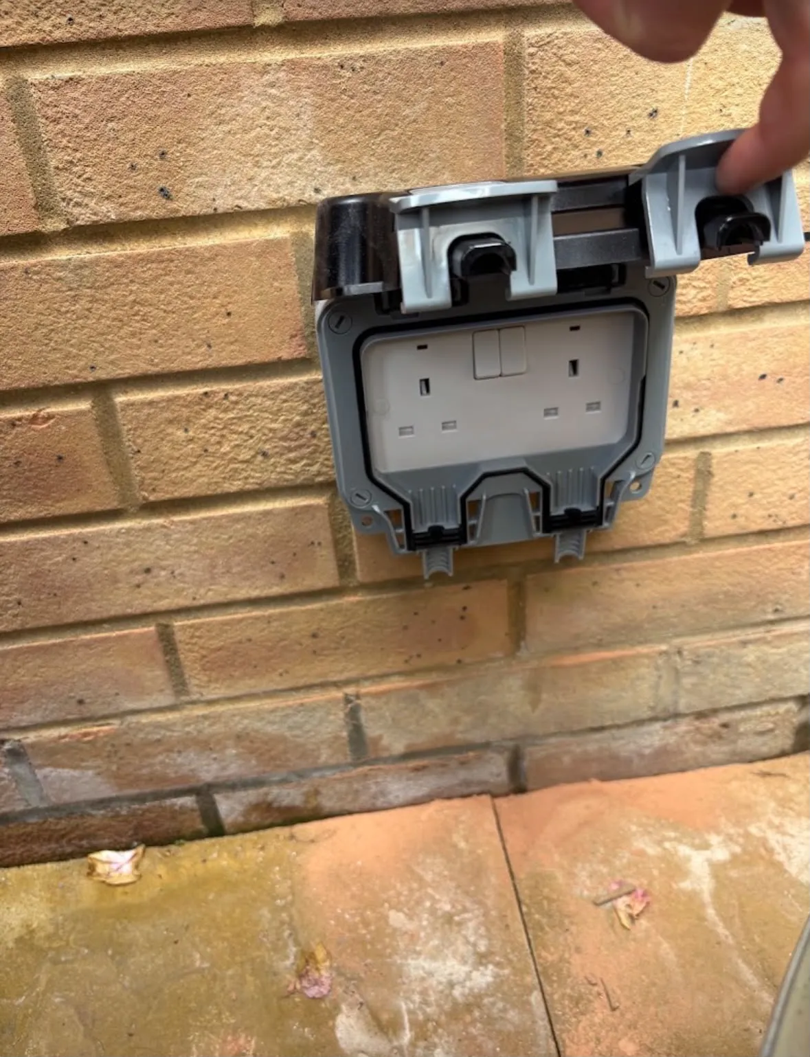 Outdoor weatherproof double socket installation on an external brick wall