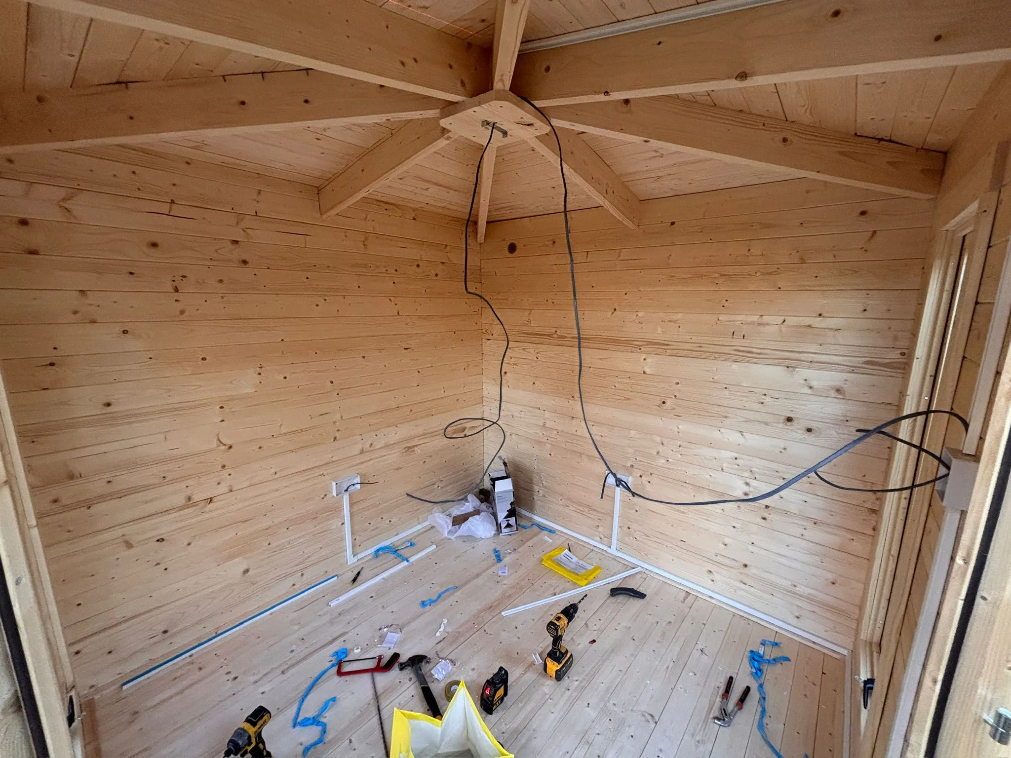 First-fix wiring and socket installation underway inside a wooden garden office