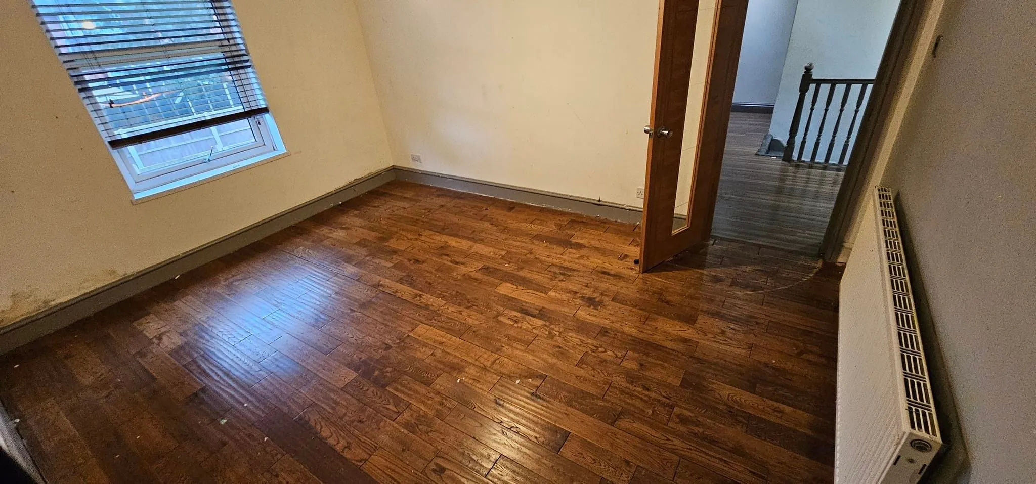 Completed domestic room clearance in Birmingham showing an empty room with wooden flooring ready for tenancy handover