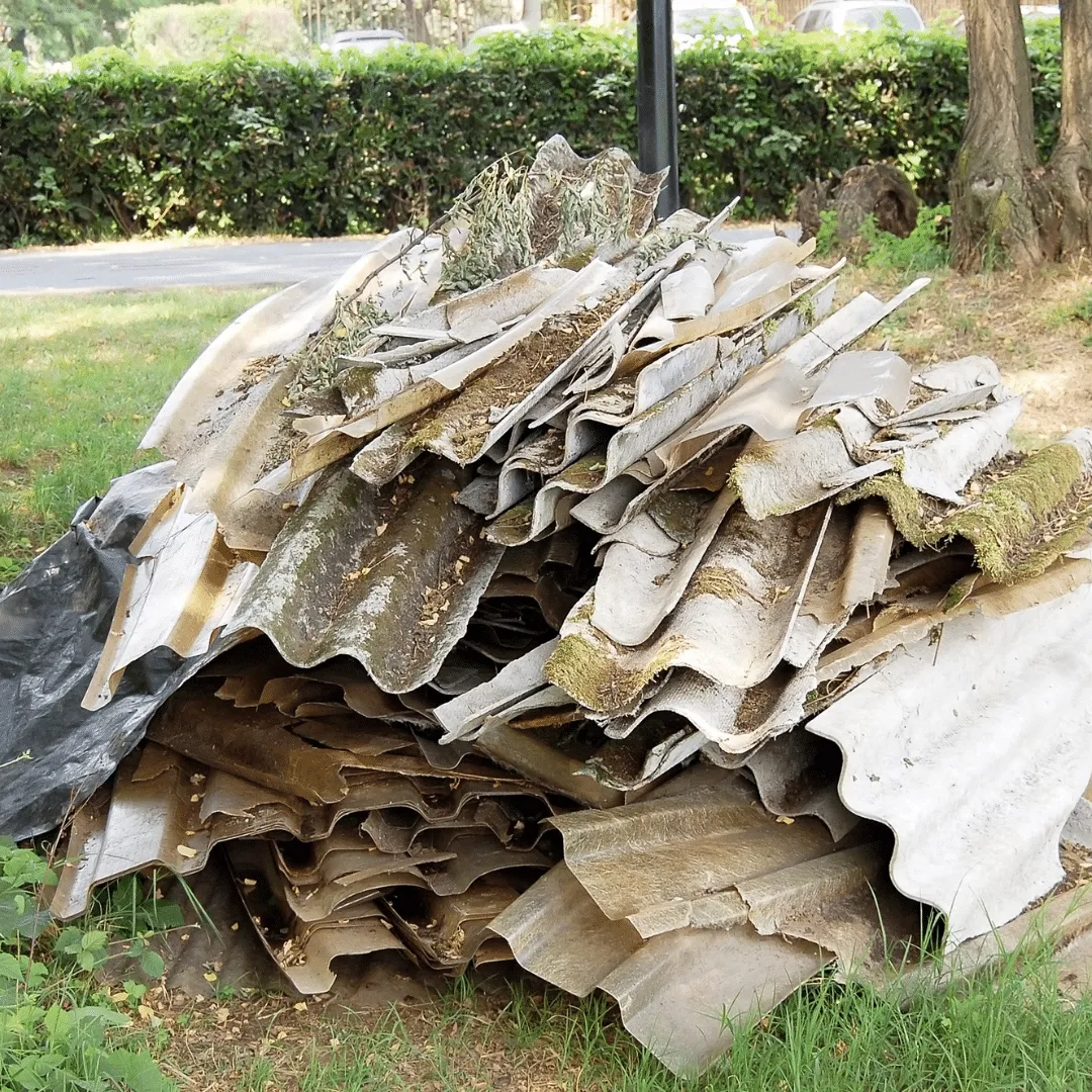 A stack of old corrugated asbestos roofing sheets awaiting safe disposal by Stay Safe Environmental.