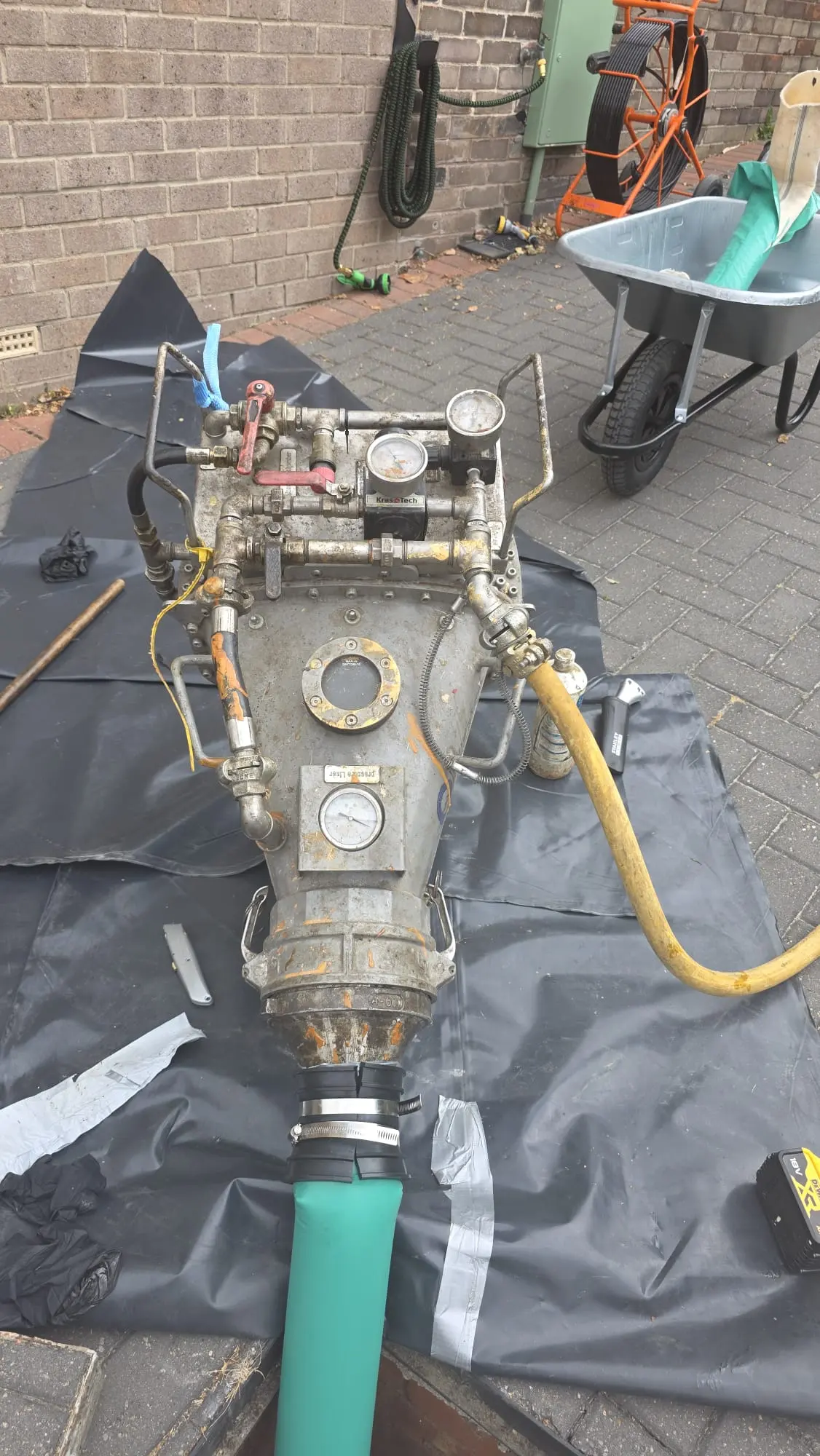 Specialist CIPP inversion drum equipment set up for no-dig drain relining on a block-paved driveway.
