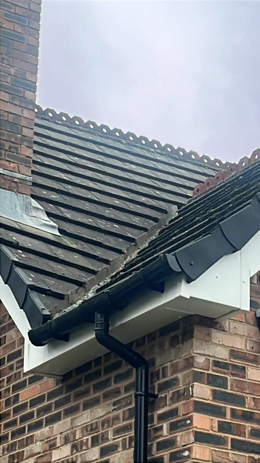 Newly installed white uPVC fascias, soffits, and black guttering on a tiled roof