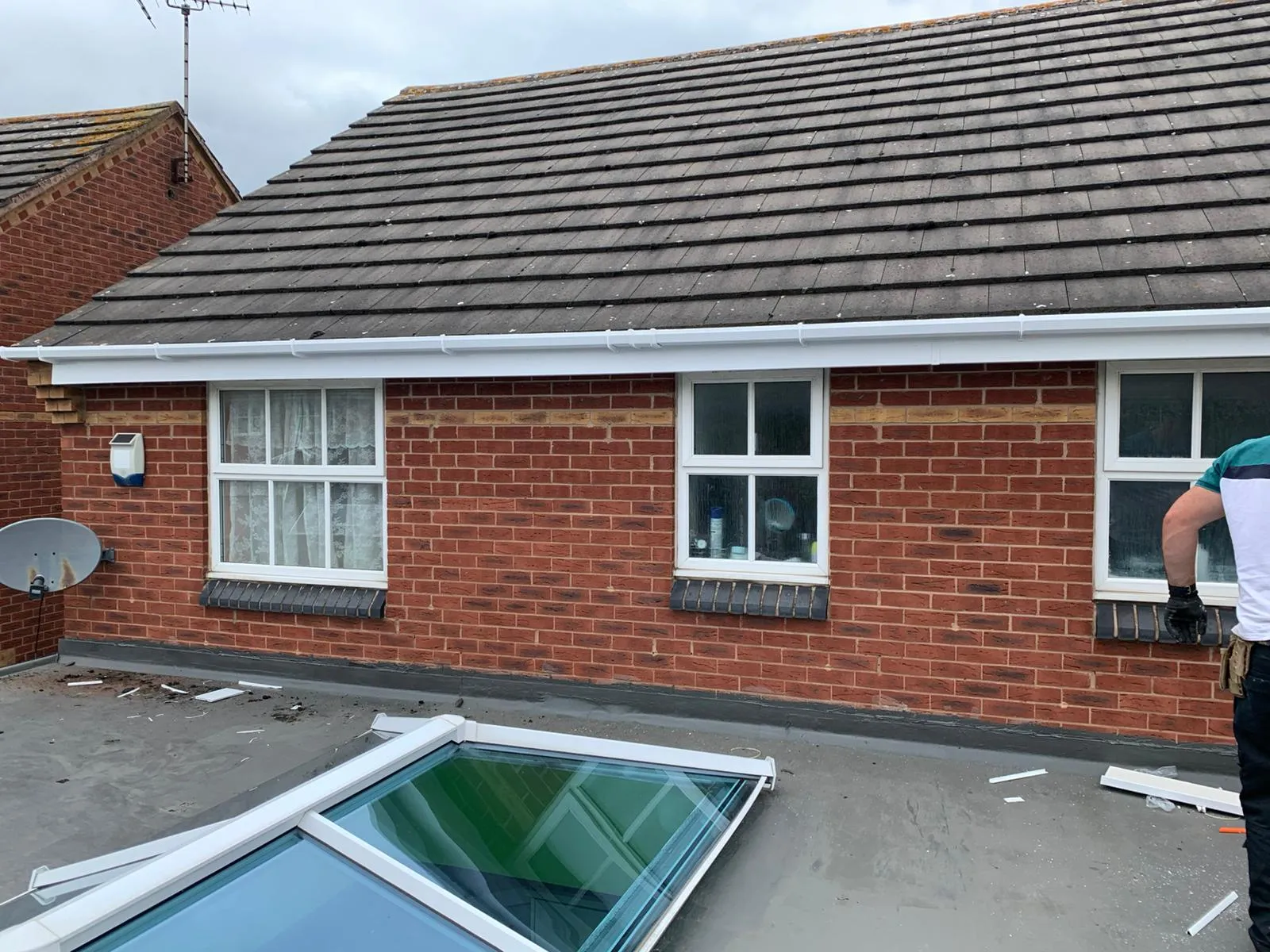 Newly installed white uPVC fascias and guttering on a brick house in Gloucestershire.