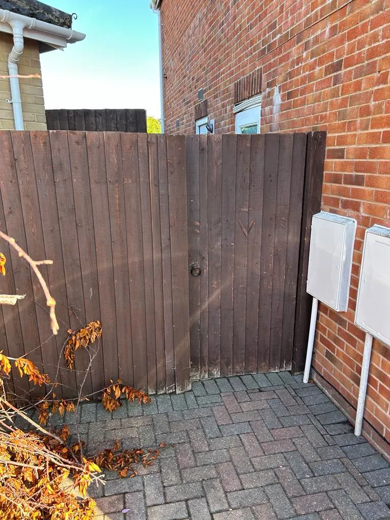 Timber garden side gate and featheredge fencing installation next to a residential property
