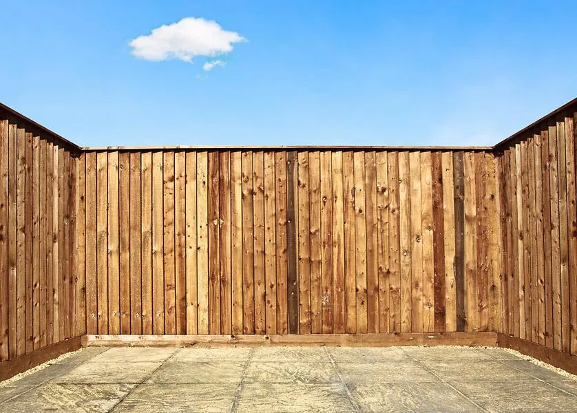 New wooden garden fence and paved patio in a corner.