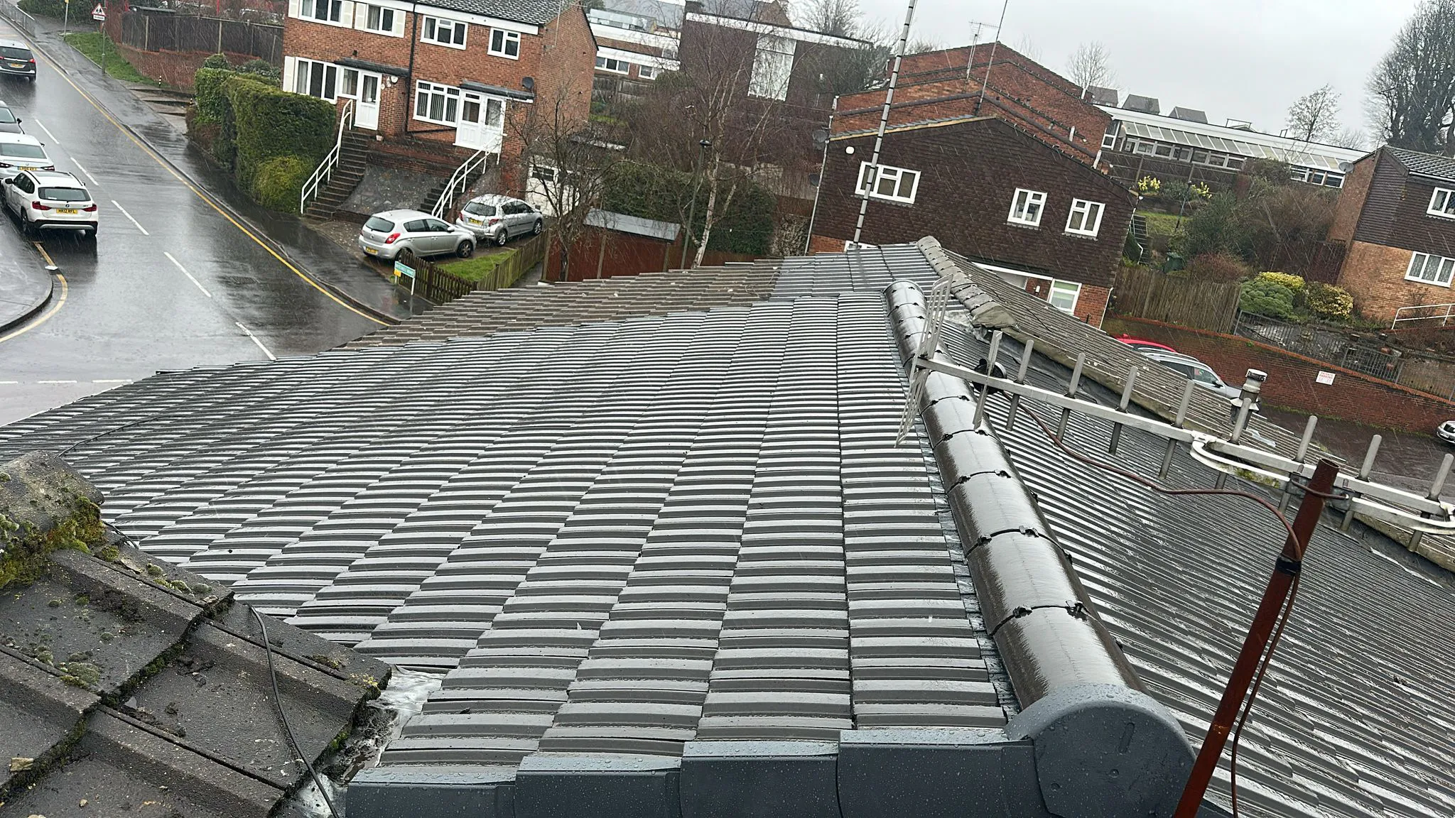 Profiled concrete interlocking roof tiles with dry ridge system and verge caps on a residential roof
