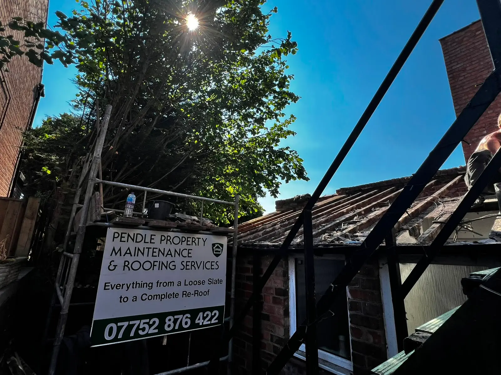 Pendle Property Maintenance sign on scaffolding during a re-roofing project in Burnley.
