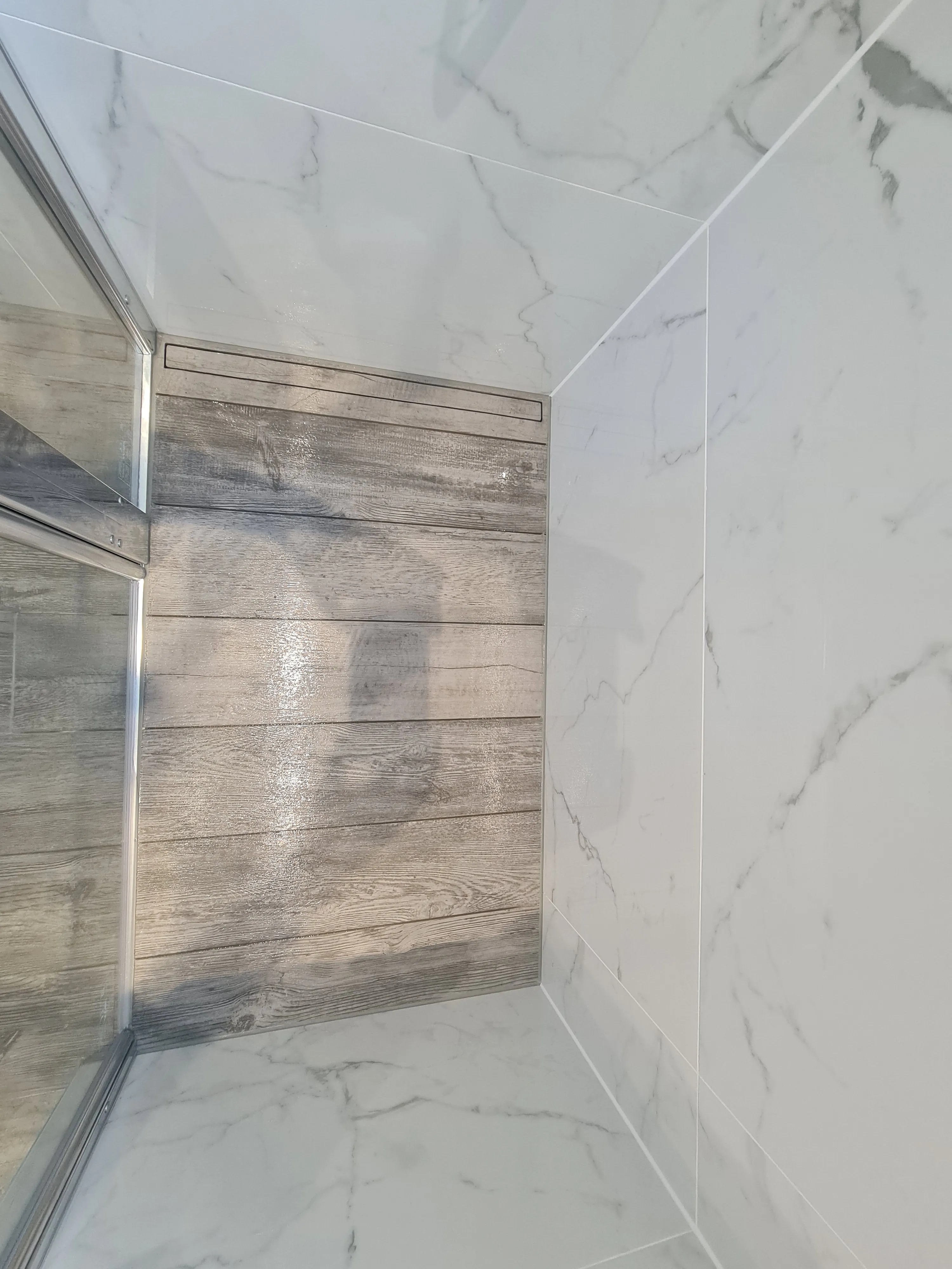 Bespoke luxury walk-in shower installation in Plymouth featuring marble tiles and a linear drain by Sands & Vossen.