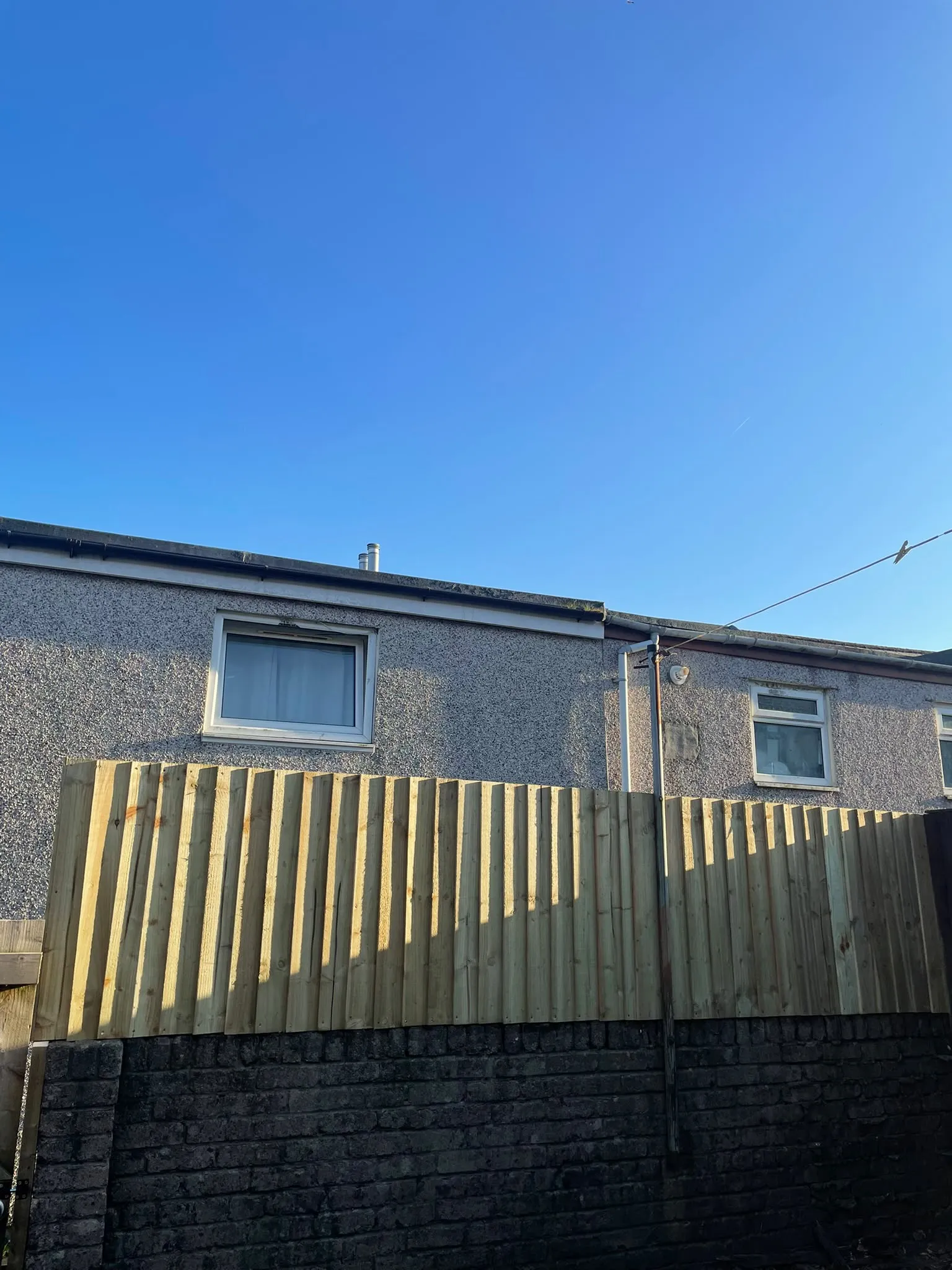 Treated timber featheredge fencing installed above a brick garden wall in Pontypool