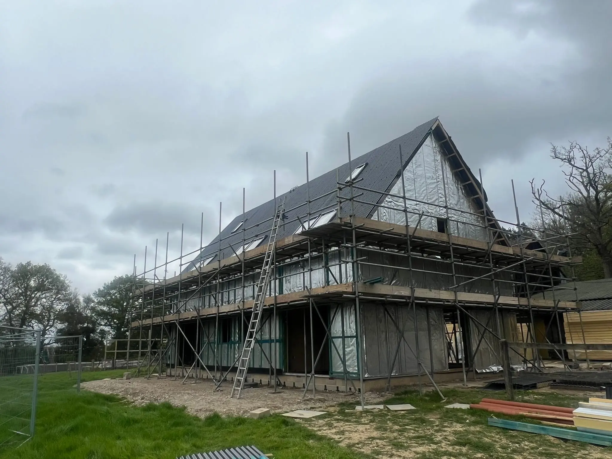 Steel-framed agricultural building under construction showing scaffolding and reflective insulation wrap installed by ER3 Group LTD