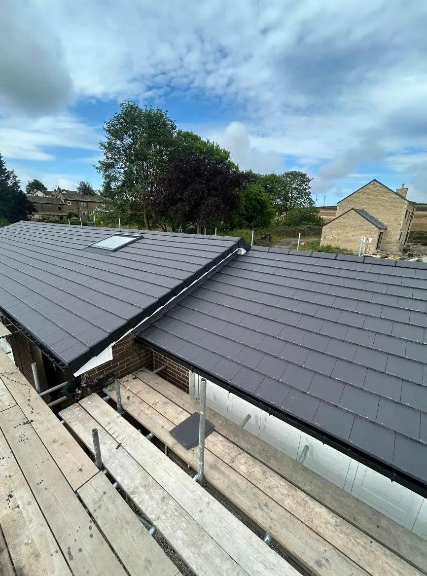 Modern new roof installation with grey tiles and skylight by Tyler’s Roofing Services in Holmfirth.