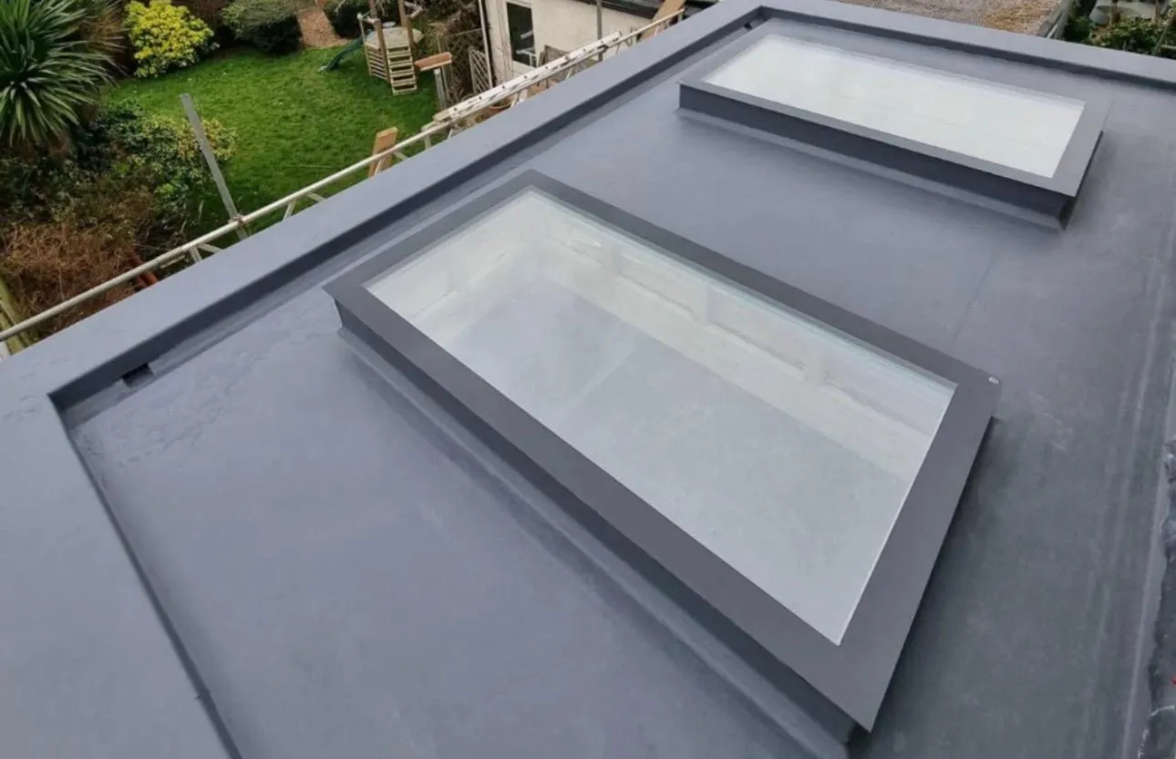 Modern grey GRP flat roof with two large skylights installed on a home by Century Roofing and Building.