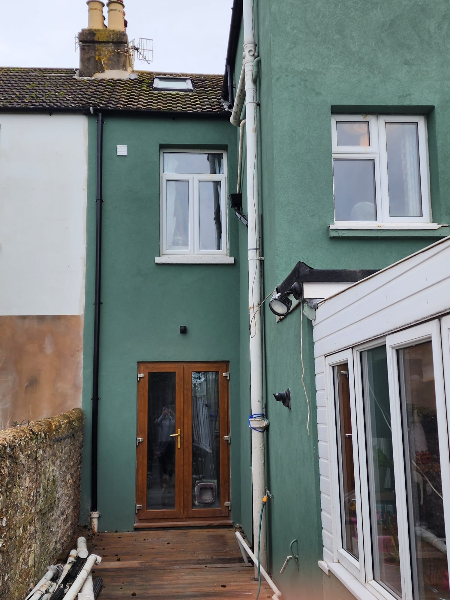 A green rendered exterior wall of a house in Portslade, showcasing high-quality external rendering services.