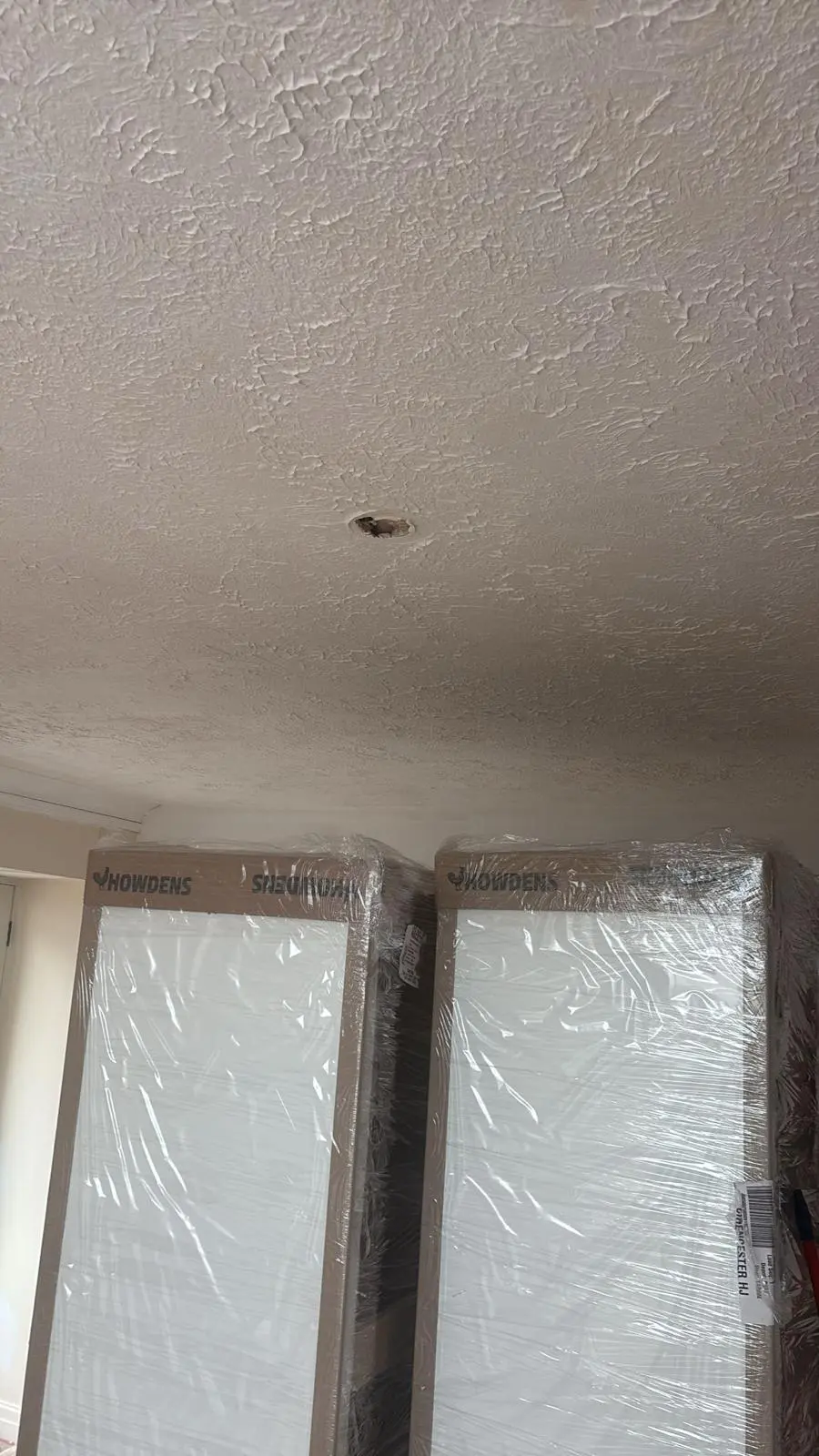 Howdens kitchen units stacked in a room ready for installation