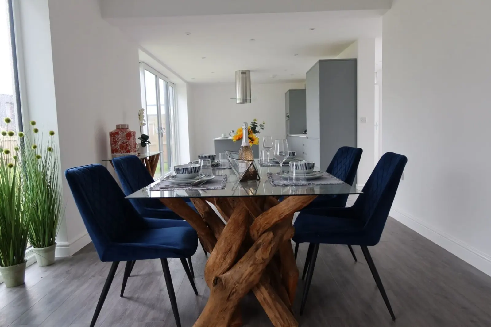 A modern open-plan dining room with smooth white walls and blue chairs, demonstrating a high-quality interior finish following internal wall insulation