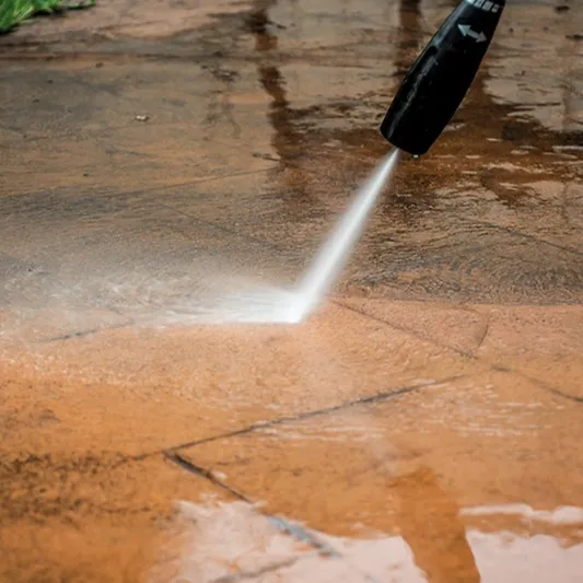 Pressure washer cleaning a patio or driveway, highlighting professional exterior cleaning services.