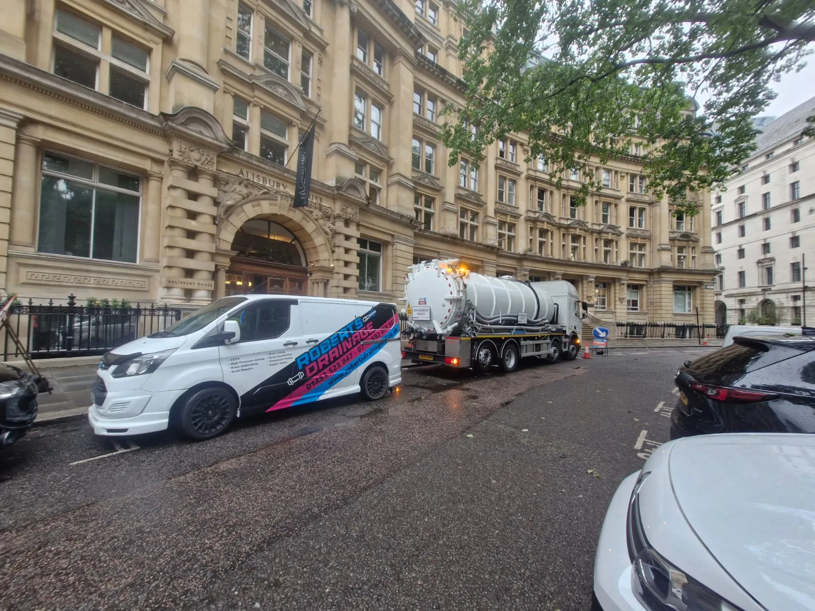 Roberts Drainage Ltd service van and tanker truck parked outside a commercial building providing professional drainage services.