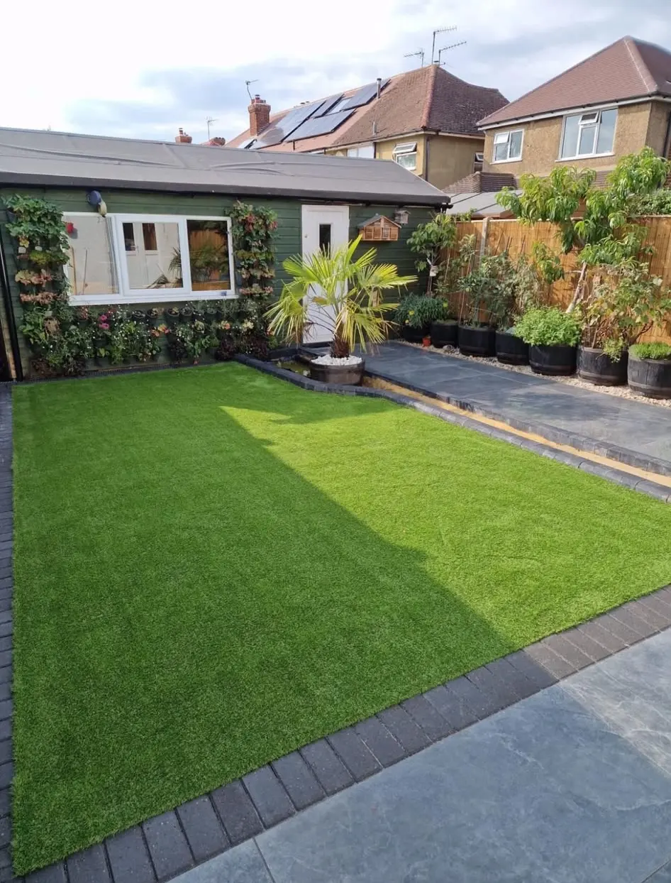 A garden transformation featuring a new artificial lawn, block paving border, and slate patio area completed by Swift Property Solutions.