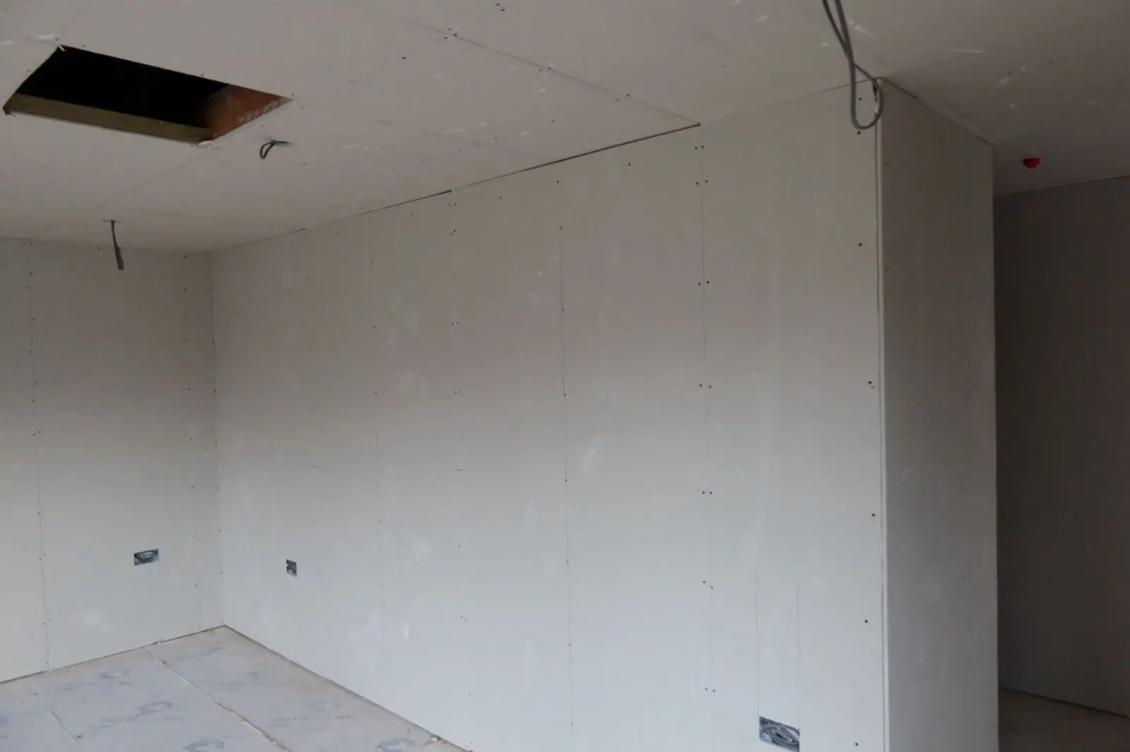 Newly installed plasterboard on walls and ceiling ready for plastering during an internal insulation project