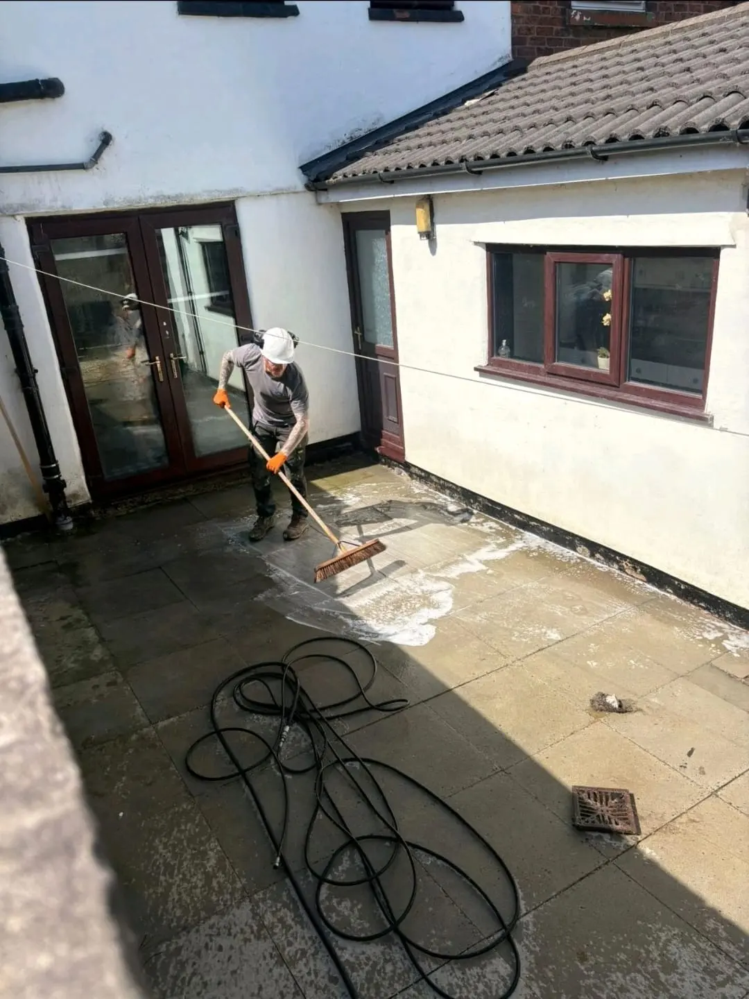 A professional providing patio cleaning and pressure washing services in Wigan