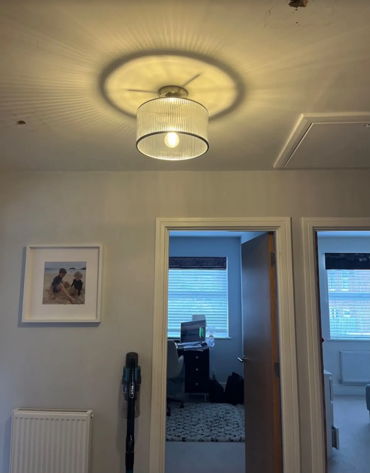 Modern ribbed glass ceiling feature light installed in a residential hallway by Sussex Brown Sparks