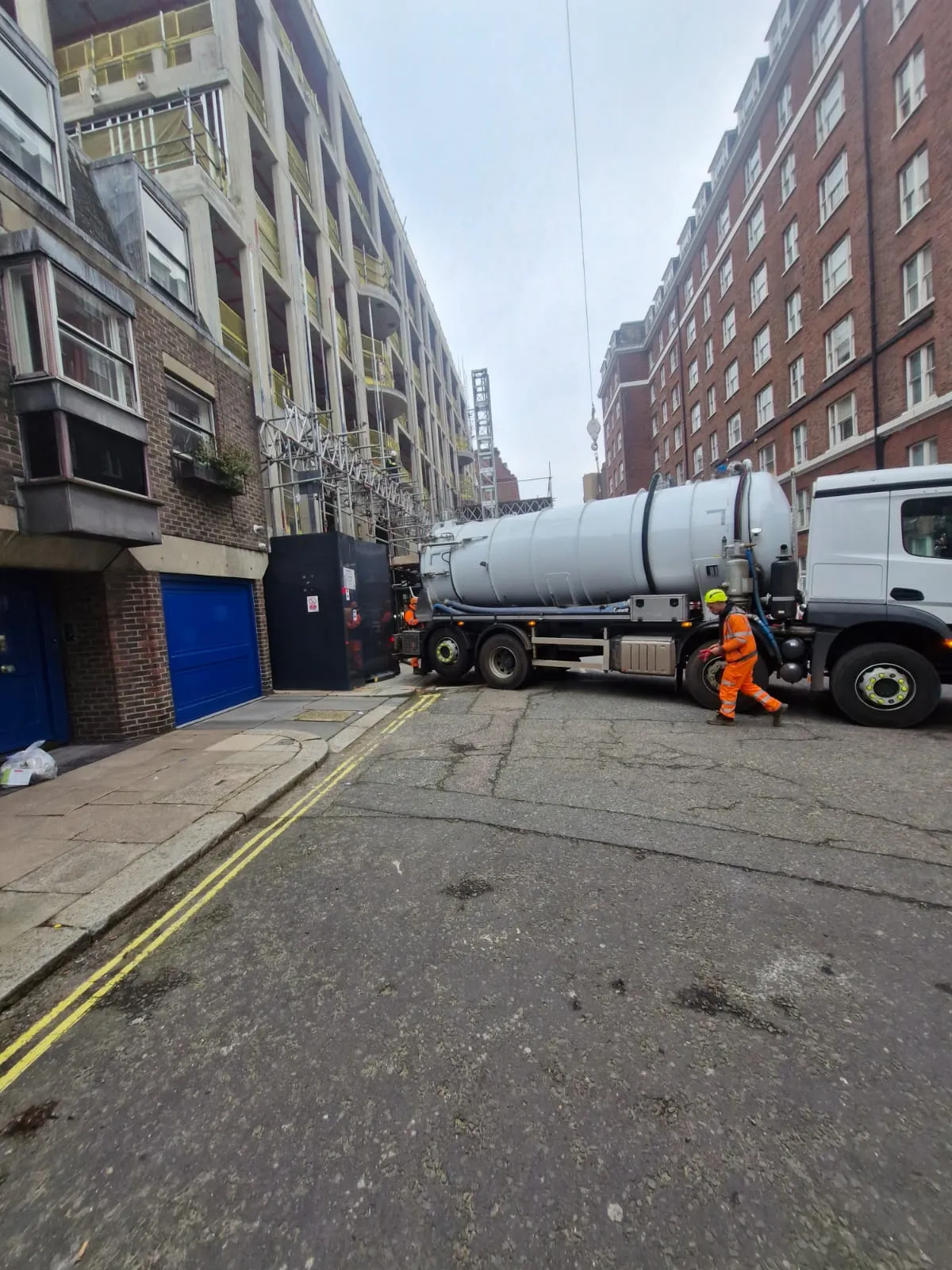 A Roberts Drainage Ltd liquid waste tanker and technician providing commercial waste management services on a city street.