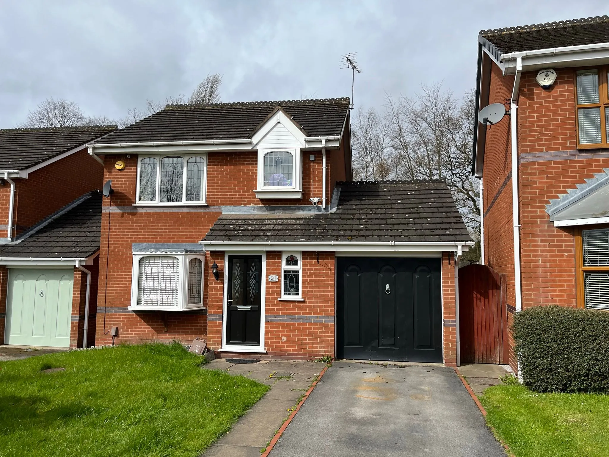 A red brick detached house with a dark roof and black garage, representing a typical home that Whites Building LTD could extend.
