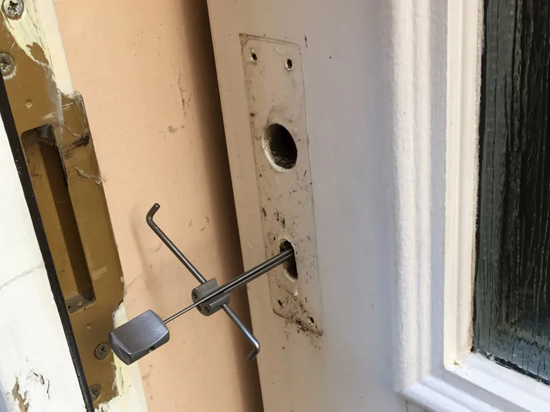 Locksmith using a picking tool for non-destructive entry on a uPVC door