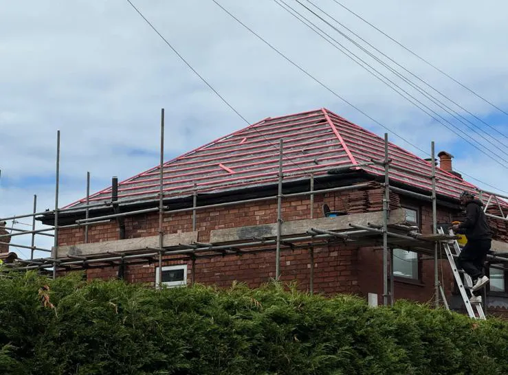 Tiled roof replacement in progress showing newly fixed battens and scaffolding on a residential property