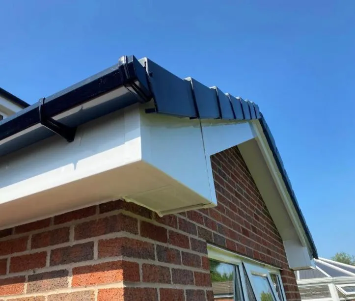 Close-up of modern black UPVC guttering and white UPVC fascias and soffits on a residential property's roofline.