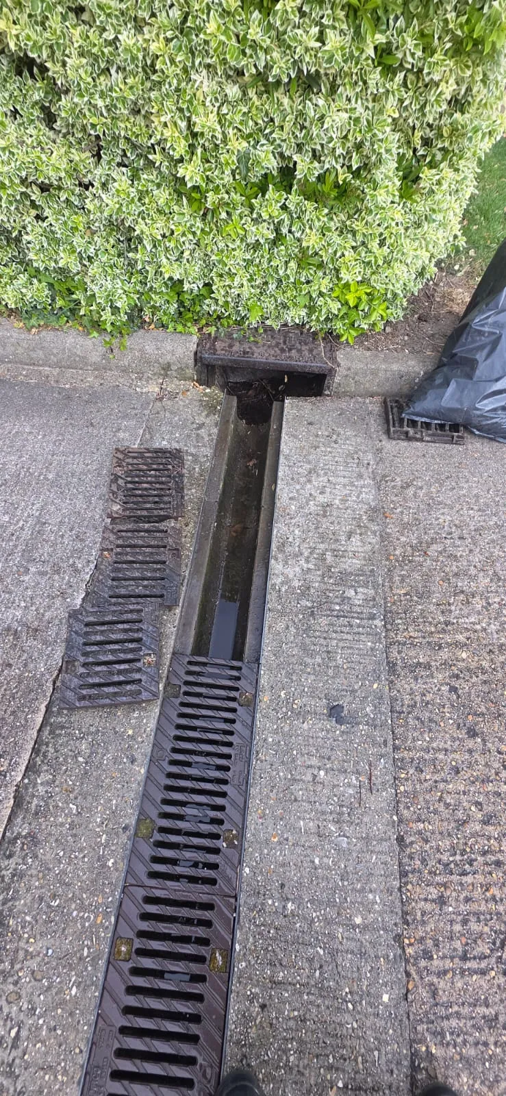 A professional drainage technician inspecting a blocked channel drain in Felixstowe