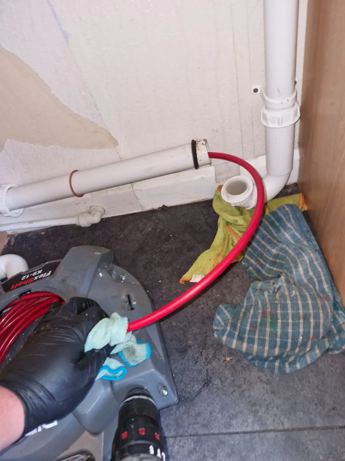 Professional drain unblocking of an internal household pipe using a mechanical cleaner.
