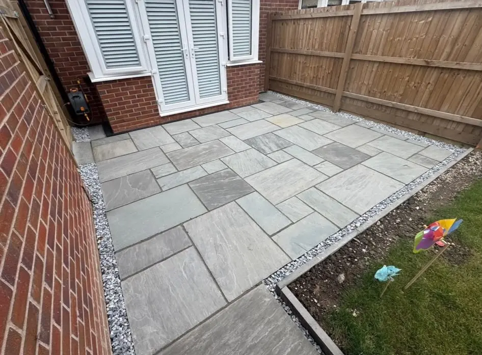 Expert grey natural stone patio installation with gravel drainage borders by Swift Property Solutions in Northampton